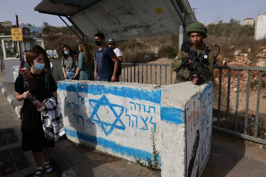 An Israeli soldier on guard at a bus station near the Jewish settlement of Ariel in Palestinian West Bank.