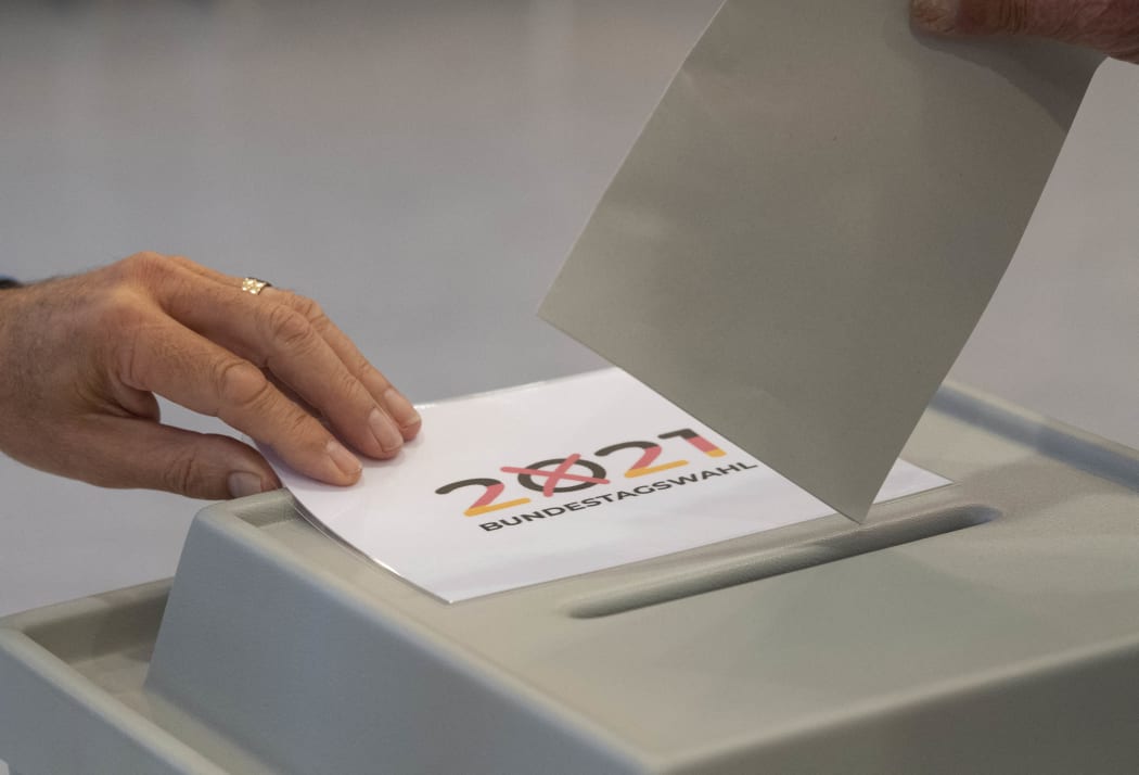 A voter casts his ballot papers for the German federal elections at a polling station in Gutach near Freiburg in the Black Forest region, southern Germany