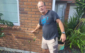 Glenn Whittington points to water line during flooding.