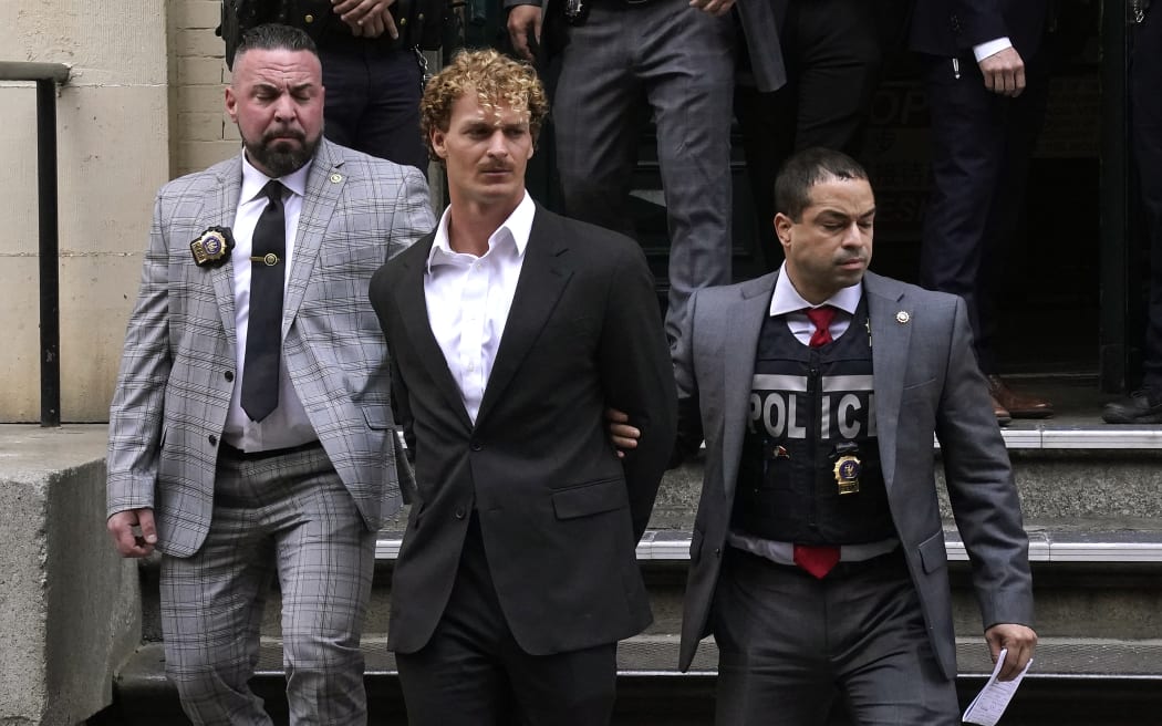 US Marine veteran Daniel Penny (C) is walked out of the New York Police Department 5th Precinct in Lower Manhattan, May 12, 2023 on his way to a arraignment after he surrendered to authorities after being charged with 2nd Degree Manslaughter in the chokehold death of Jordan Neely. The death of Jordan Neely -- widely identified as a Michael Jackson impersonator who often performed on the train -- earlier this month sparked outrage. (Photo by TIMOTHY A. CLARY / AFP)