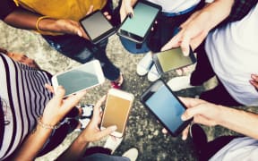 Diverse friends using their phones.