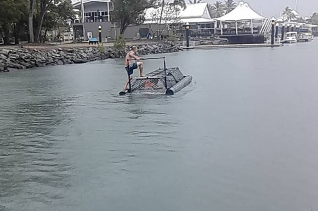 A man standing on top of a baited crocodile trap in Australia.