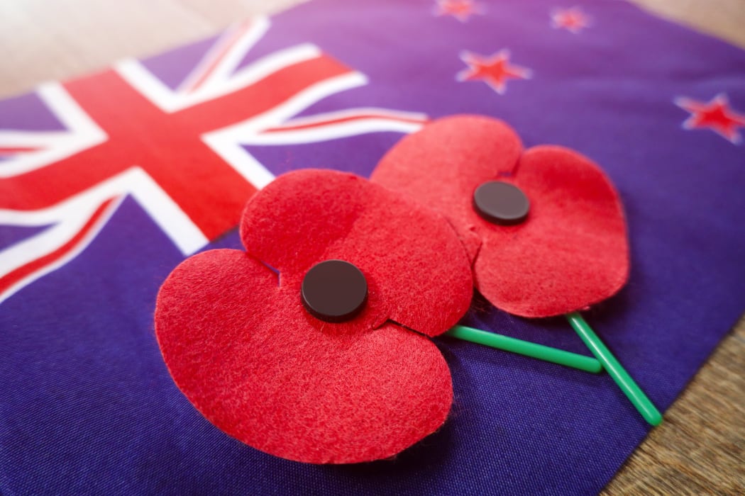Close up on Remembrance poppies on a New Zealand flag.