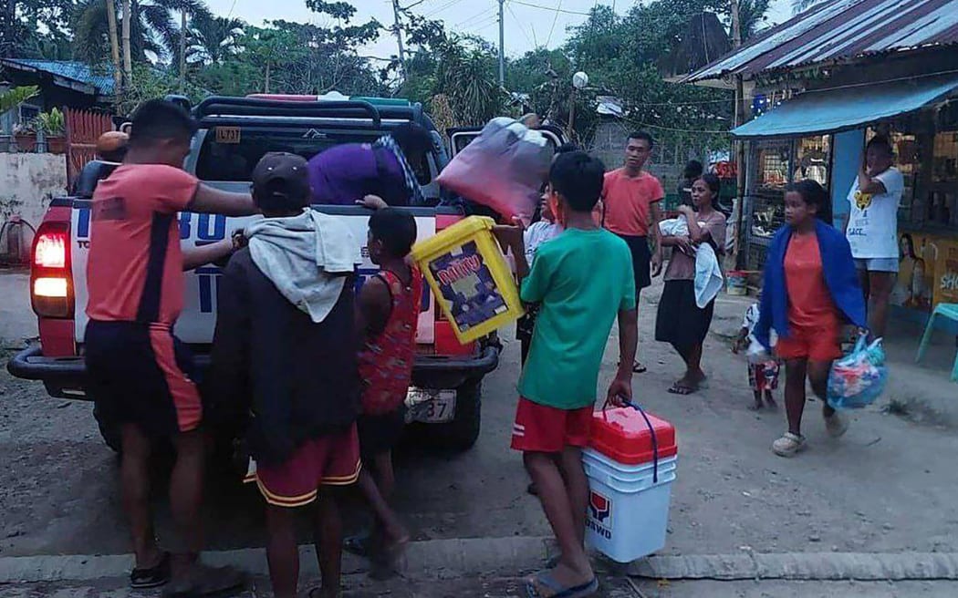 Coast guard personnel assisting residents to evacuate before Typhoon Fung-wong makes landfall in Mobo, Masbate province. Rescue work was suspended and preemptive evacuations began on November 8 as Typhoon Fung-wong bore down on the Philippines.