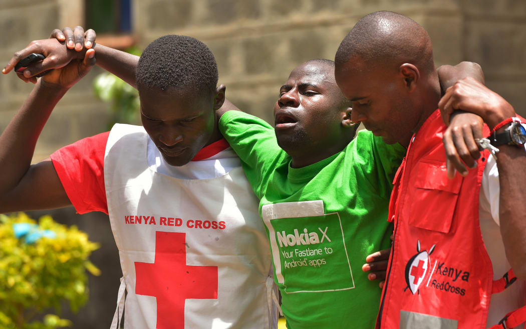 Red Cross workers help a relative of one of the students killed by al-Shabaab gunmen.
