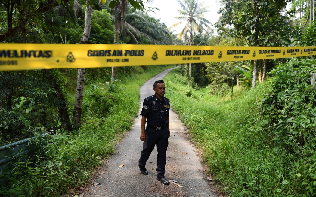 A policeman walks near a police line at an entrance to the Dusun Resort, where missing 15-year-old teenager Nora Quoirin was last seen, in Seremban on 13 August.