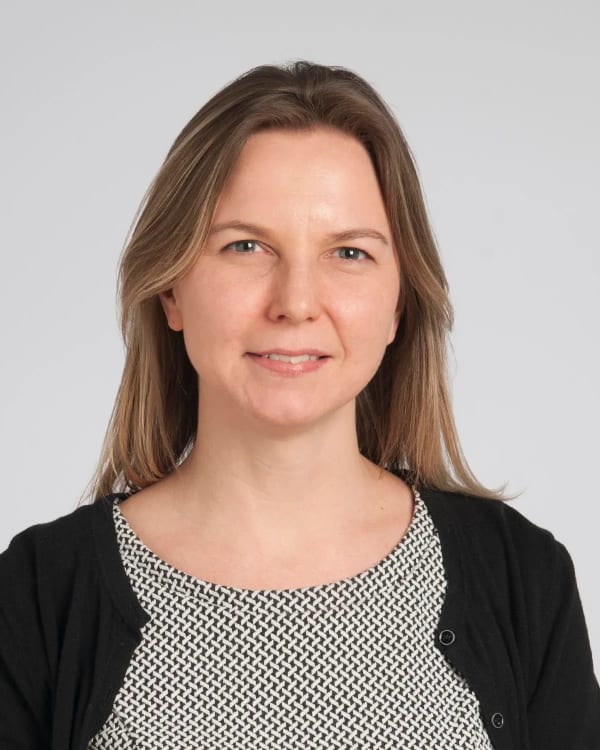 Dr Michelle Drerup is a long-haired woman with a gentle smile, wearing a black and white patterned top and black cardigan.