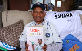 Nanubhai Ranchhod delightedly holds his prized Sachin Tendulkar book.