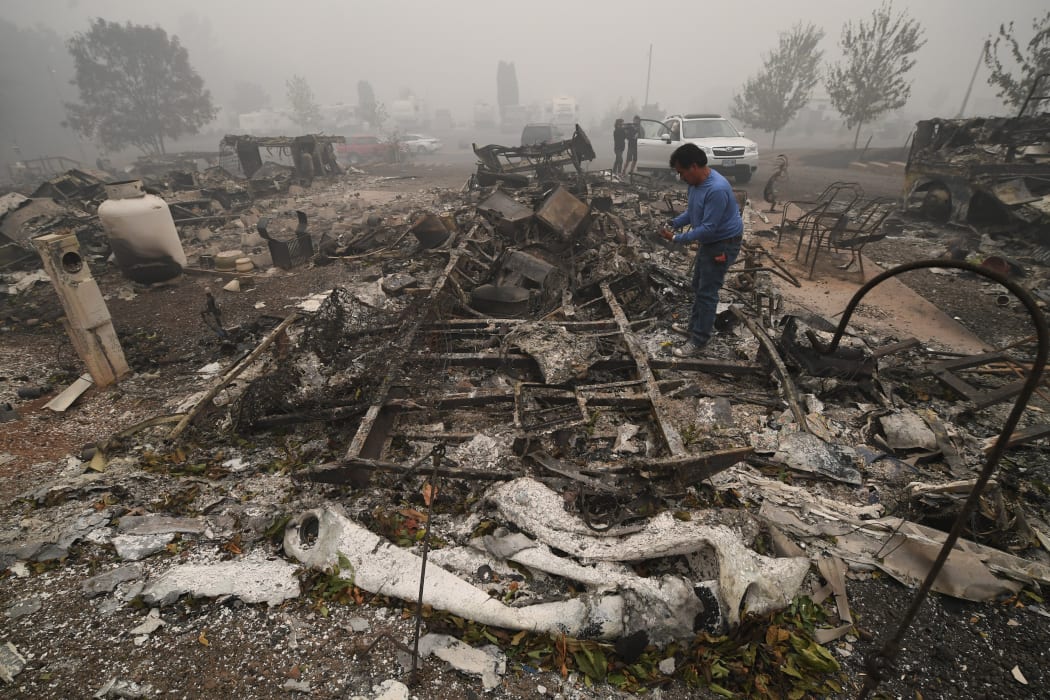 A man looks for items in the remains of his mobile home after a wildfire swept through the R.V. park destroying multiple homes in Estacada, Oregon
