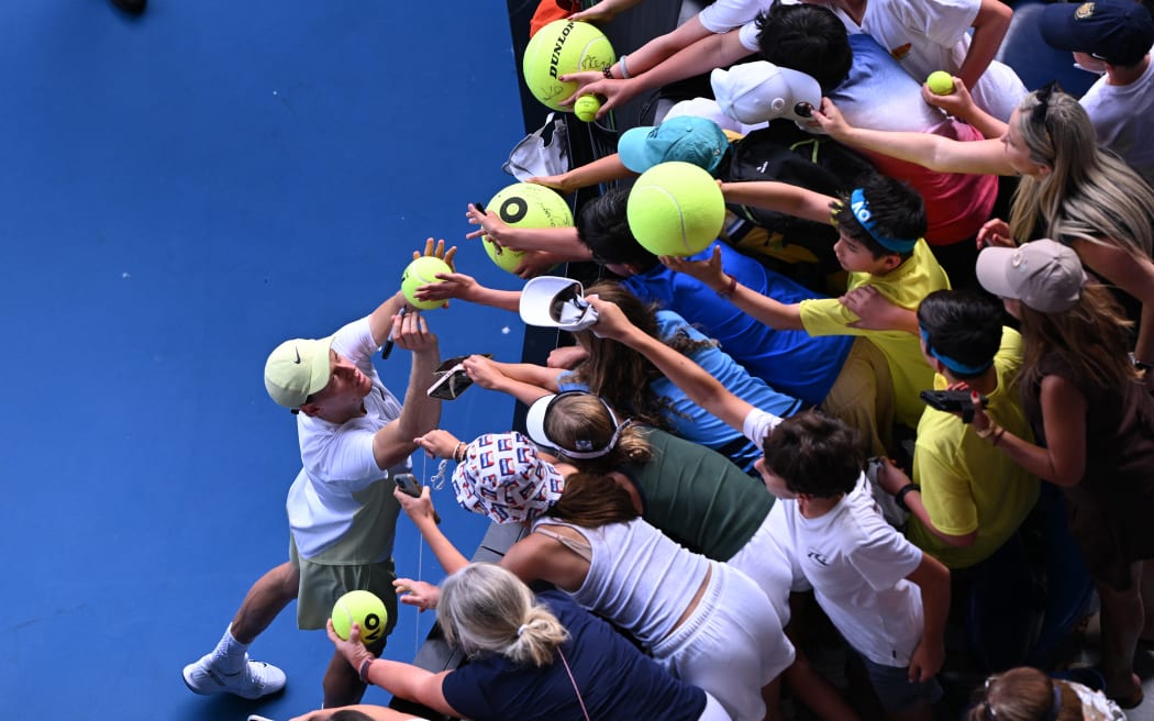 Italy's Jannik Sinner signs autographs for fans at the Australian Open.