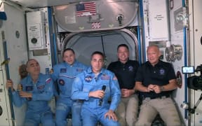 NASA astronauts Doug Hurley (R) and Bob Behnken (2R) join NASA astronaut Chris Cassidy (C) and Russian cosmonauts, Anatoly Ivanishin (L) and Ivan Vagner (2L) aboard the International Space Station after successfully docking SpaceX's Dragon capsule May 31, 2020.