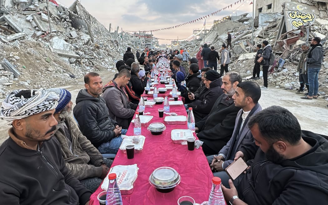 Palestinians gather for a communal iftar, or fast-breaking meal, on the first day of the Muslim holy month of Ramadan, amid building rubble in Rafah in the southern Gaza Strip on March 1, 2025. (Photo by AFP)