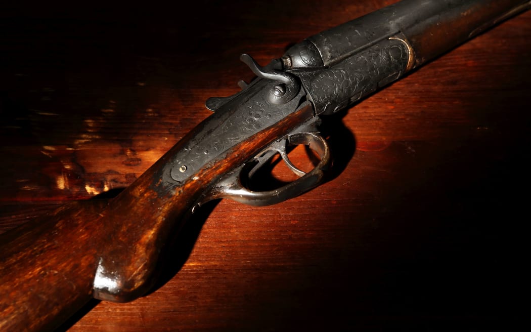 Ancient hunting shotgun closeup on wooden background