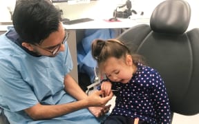 A young girl gets her teeth checked