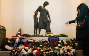 Wind loudly buffeted the hall where wreaths were laid near a statue named 'Mother and Children', representing families left behind during wartime.