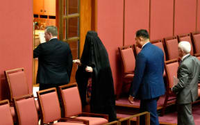 Pauline Hanson leaves the Senate, wearing a burka, after proceedings were suspended.