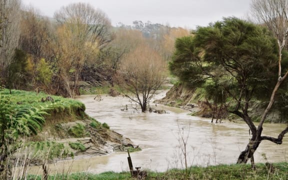 The Pakarae River, where State Highway 35 crosses it. on 23 June 2023. Previous scouring of banks shows where the water level was during Gabrielle.