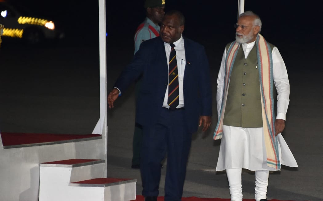 India's Prime Minister Narendra Modi, right, walks with his Papua New Guinea counterpart James Marape at Port Moresby International Airport on 21 May, 2023, ahead of the Forum for India–Pacific Islands Cooperation (FIPIC) summit in Papua New Guinea.