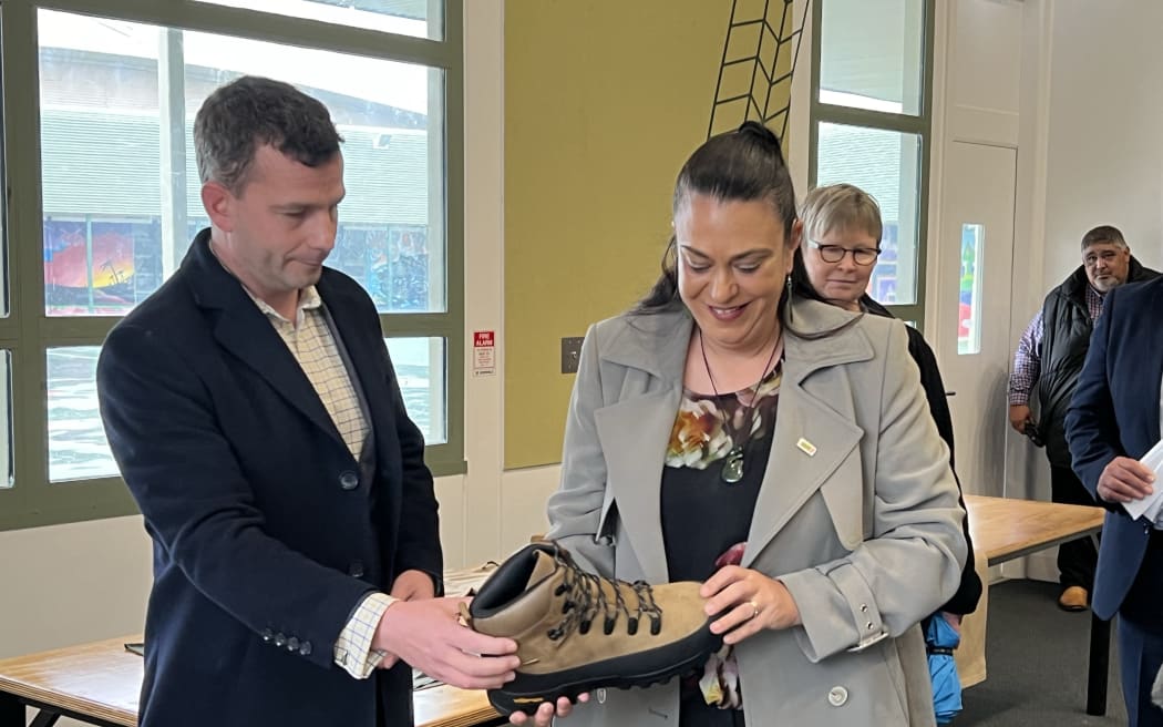 Acting Prime Minister David Seymour and Minister for Children Karen Chhour look at the type of footwear youth at the new military academy pilot will receive.
