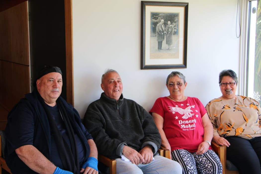 Rangiora musician Bobby Thompson-Browne, Tuahiwi kaumātua Tira-Roa Reuben and Tawhai Kimura, and Tuahiwi local Liz Kereru sitting underneath a photo of former Labour MP for Southern Māori, Eruera Tirikātene at Tuahiwi marae.