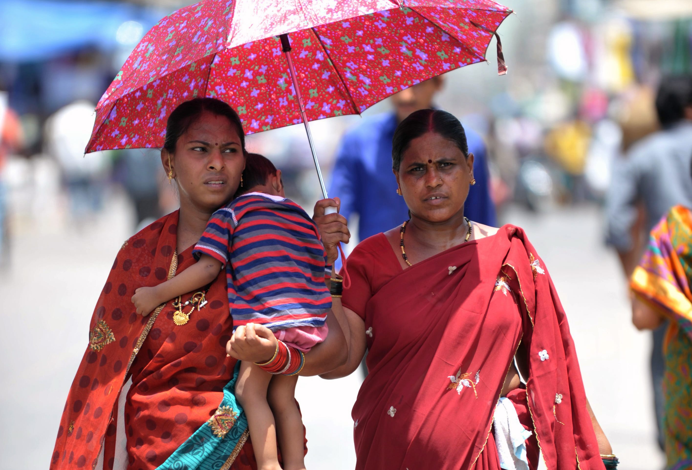 Two women and a child shelter under an umbrella in Hyderabad on Monday.