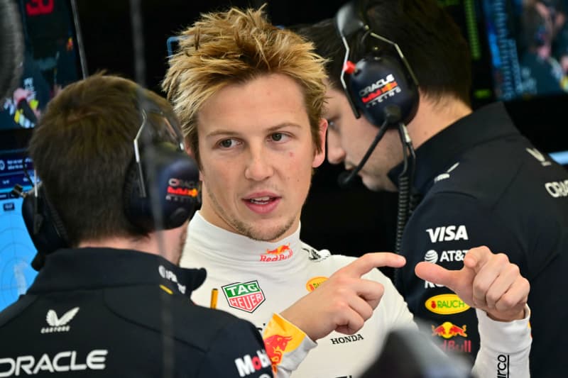 Red Bull Racing's New Zealand driver Liam Lawson speaks with a member of his pit crew on the first day of the Formula One pre-season testing in Bahrain, 2025.