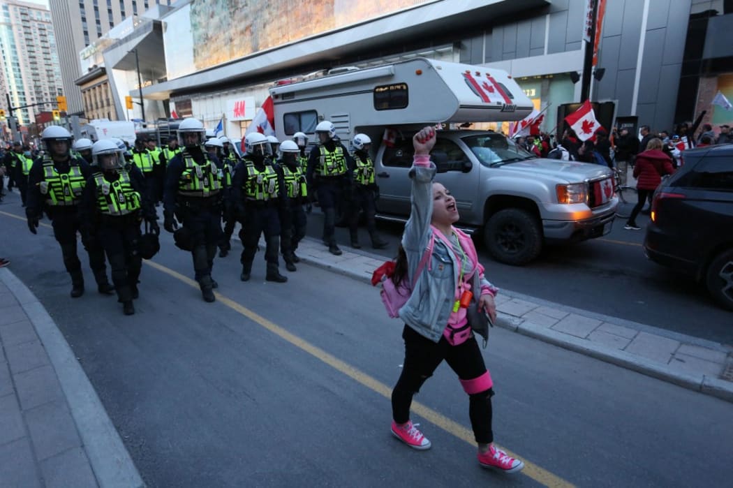 A supporter of the Rolling Thunder Convoy yells ahead of riot police officers during a protest April 29, 2022 in Ottawa, Canada.