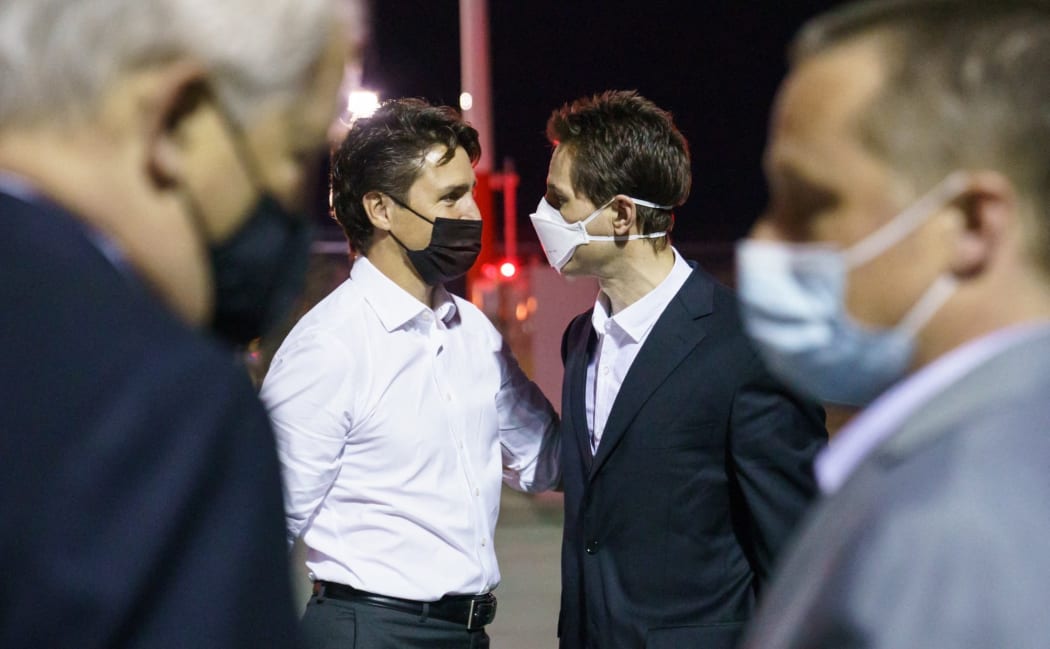 Michael Kovrig (center right) and Michael Savor (right) - accused of espionage by China, are greeted by Canada's Prime Minister Justin Trudeau as they return to Calgary, Canada,