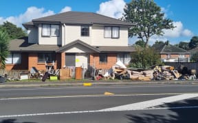 Debris is seen piled up outside a house in the Auckland suburb of Mt Roskill following the Auckland floods of January 2023.