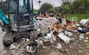 Piles of wet, smelly furniture, carpets, toys, and gib line the roads in Waiohiki, Napier after Cyclone Gabrielle.