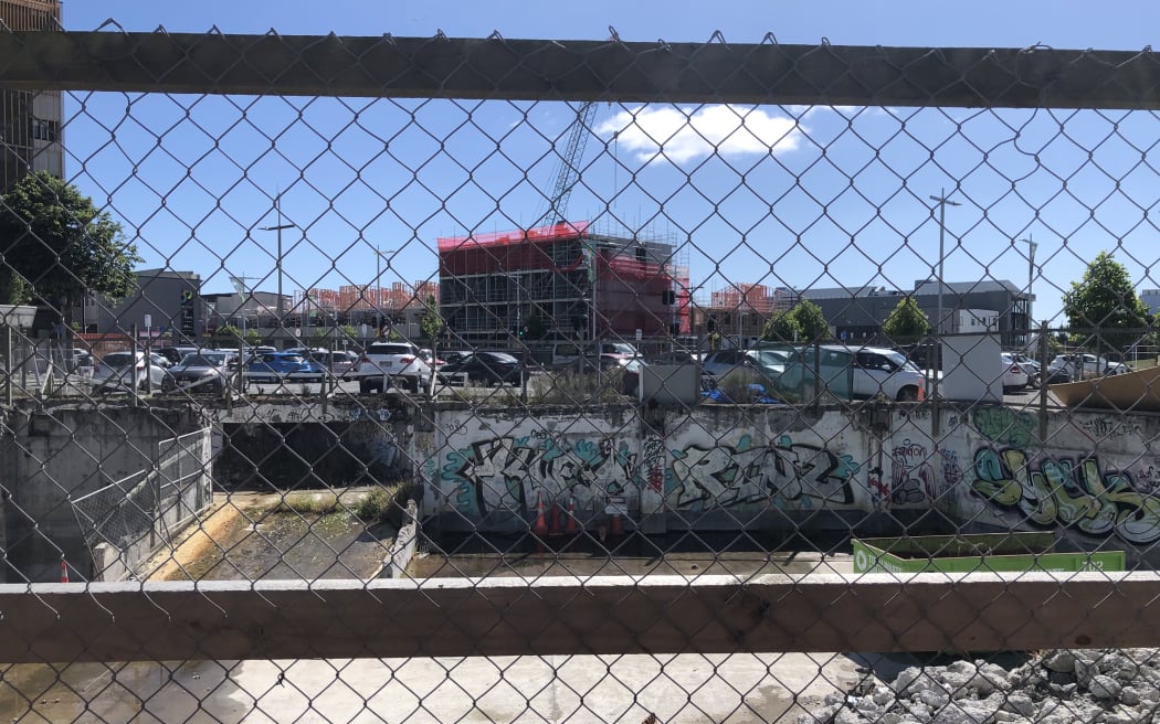 An empty lot in central Christchurch, with graffiti on walls.