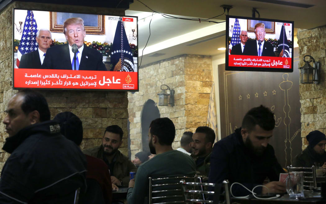 Palestinians in a cafe in the West Bank city of Ramallah as TV screens show US President Donald Trump announcing the recognition of the disputed city of Jerusalem as Israel's capital.