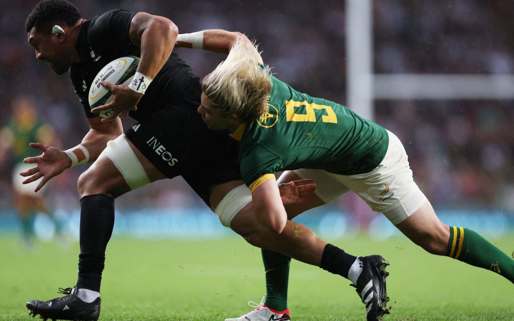 Ardie Savea is tackled by South Africa's Faf de Klerk during the match between New Zealand and South Africa at Twickenham Stadium in London.