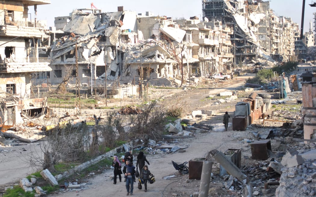 Civilians leaving a besieged district in Homs.