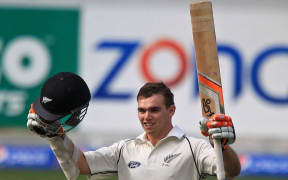 Tom Latham celebrates his century.