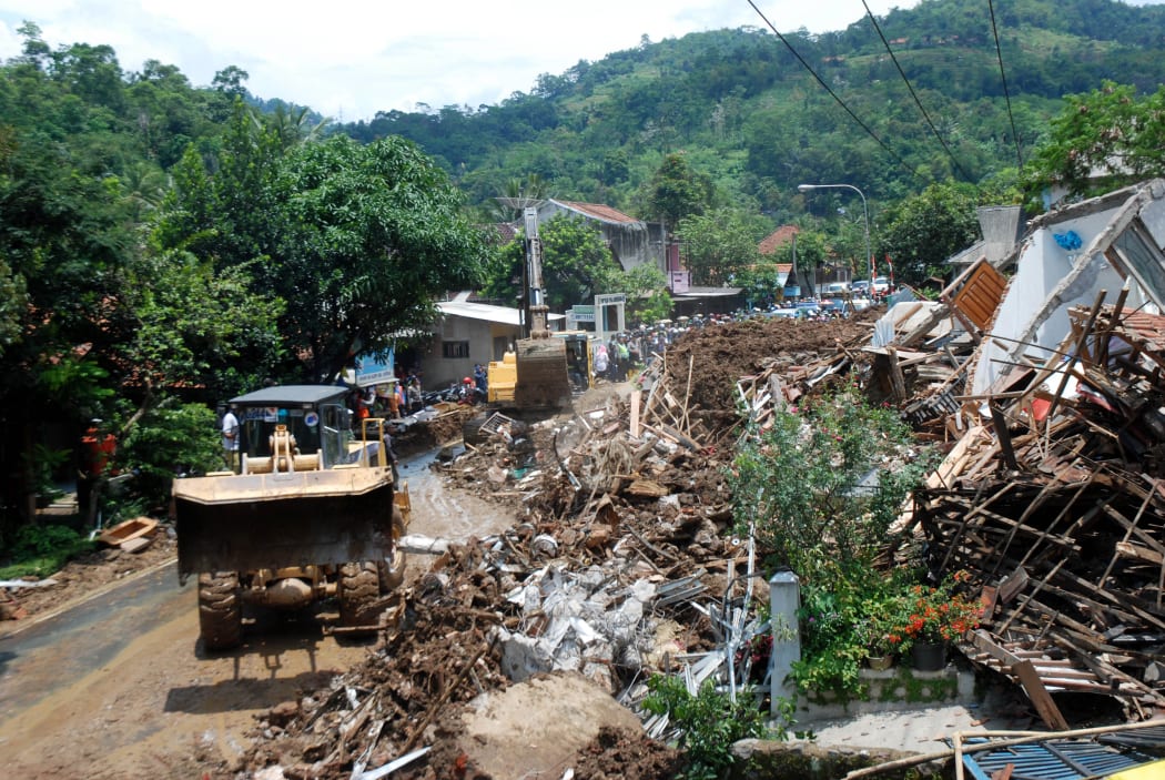 An Indonesian search and rescue team joined by volunteers remove debris from an area hit by a landslide in Sumedang on 21 September.