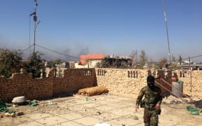 A member of the Iraqi police forces - face covered - during clashes with jihadists in Ramadi in March 2015.