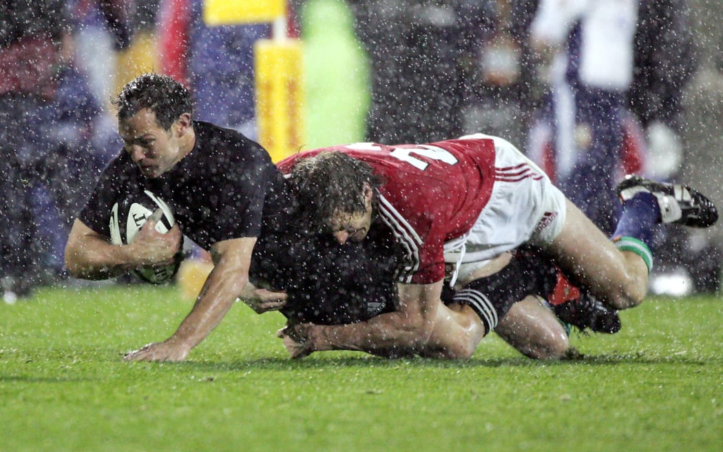 All Black fullback Leon Macdonald is tackled by Will Greenwood during the first 2005 Test.