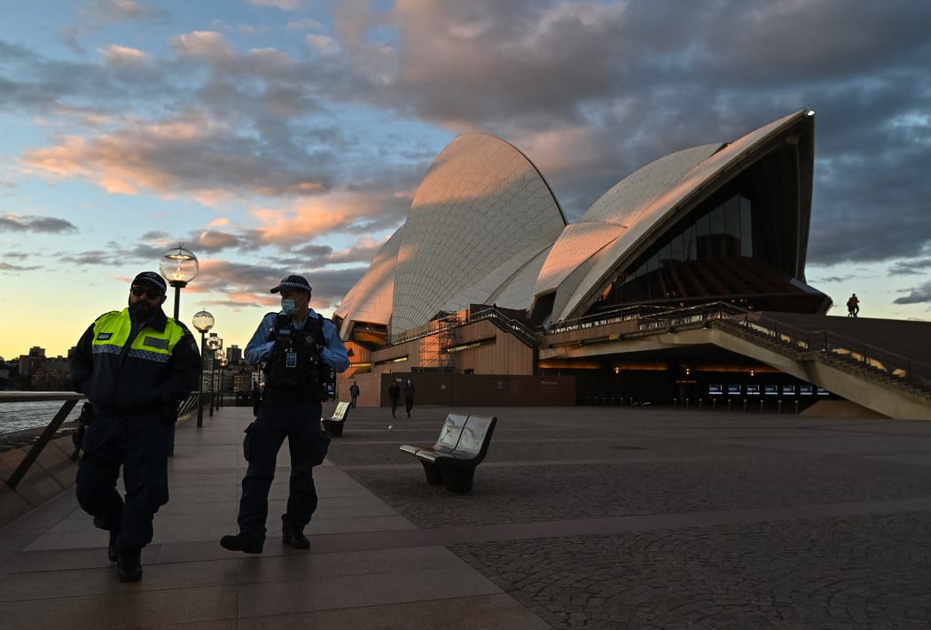 SYDNEY, AUSTRALIA - JUNE 26: Police officers walk past The Sydney Opera House during the first day of lockdown in Sydney, Australia, Saturday, June 26, 2021.