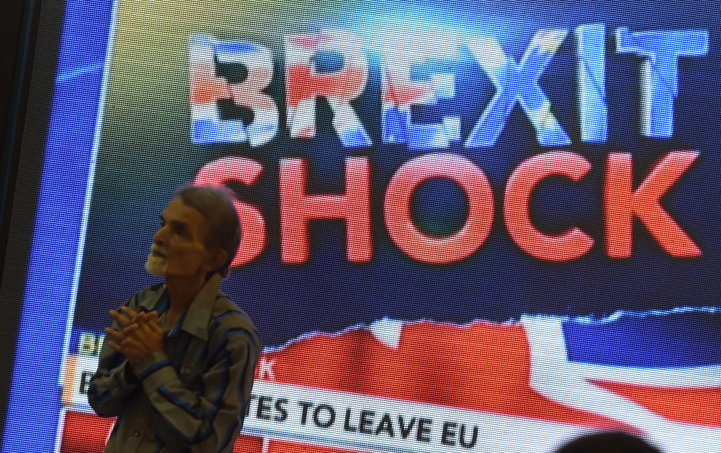 An Indian pedestrian gestures as he stands near a large screen showing news of Britain's vote to exit the European Union in Mumbai on 24 June 2016.