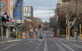 A woman walks across an empty intersection in Christchurch, New Zealand, on April 16, 2020. New Zealand is currently in alert level four.