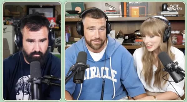 Two bearded men and a woman speak into microphones.