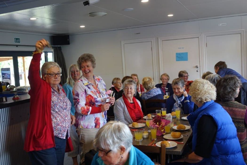 Vicar Dawn Daunauda prepares to deliver grace as Awatere Garden Club president Helen Harris rings the bell to silence the crowd having a pre-Christmas luncheon in Seddon.