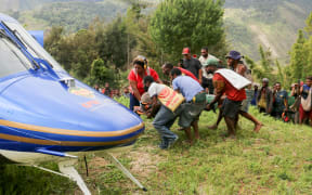 Injured villager on a stretcher being evacuated by helicopter from Kombul village to the nearby the city of Lae following a 7.6-magnitude earthquake which struck off Papua New Guinea's coast.