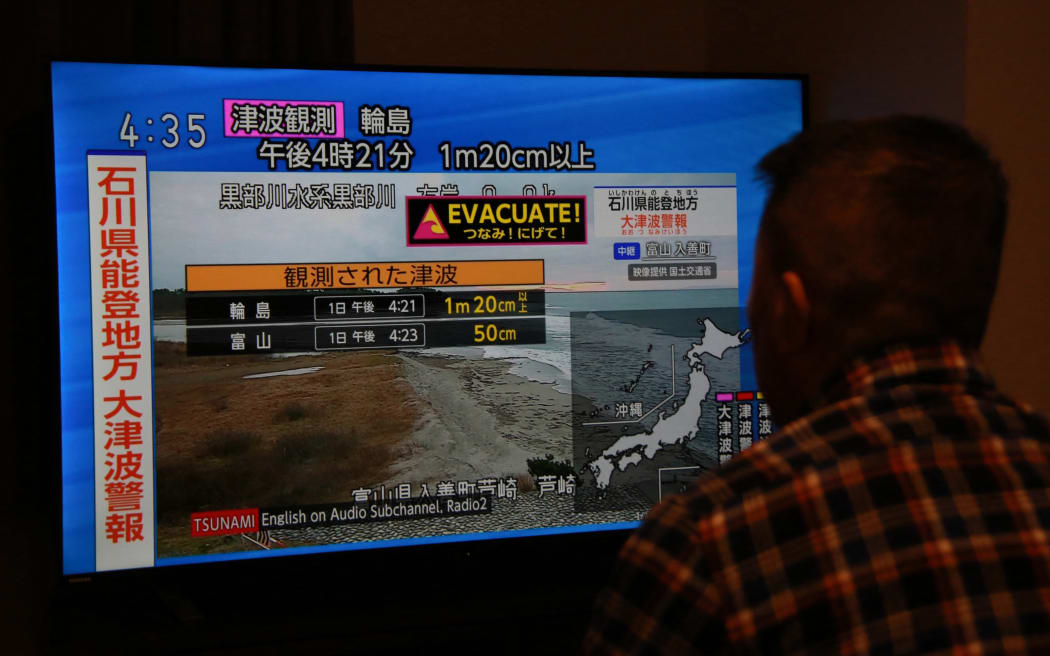 A man in Toyko watches a news report after an earthquake near Ishikawa Prefecture, Japan.
