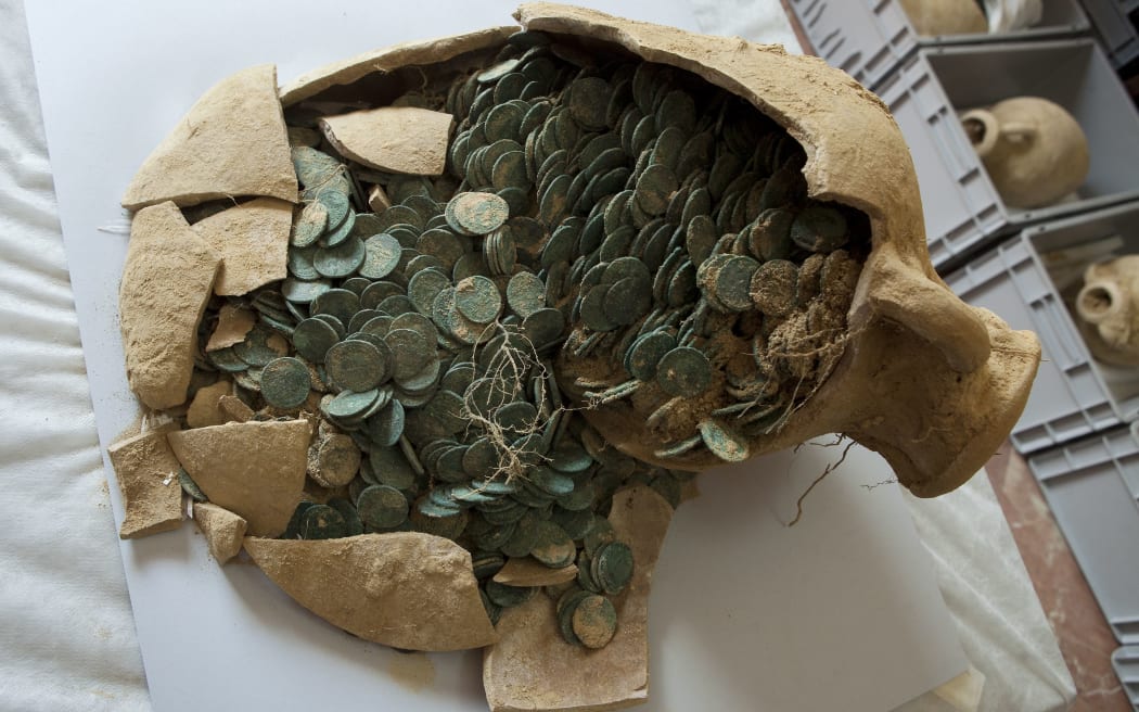 A Roman era amphora filled with bronze coins is displayed at the archaeological museum in Seville.