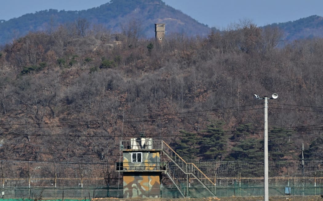 A North Korean guard post (top) is seen over a South Korean military fence (bottom) from the border city of Paju on March 13, 2023. South Korea and the United States kicked off the Freedom Shield joint military exercise, their largest drills in five years, which will run for 10 days from March 13, 2023 as part of the allies drive to counter North Korea's growing threats. (Photo by JUNG YEON-JE / AFP)