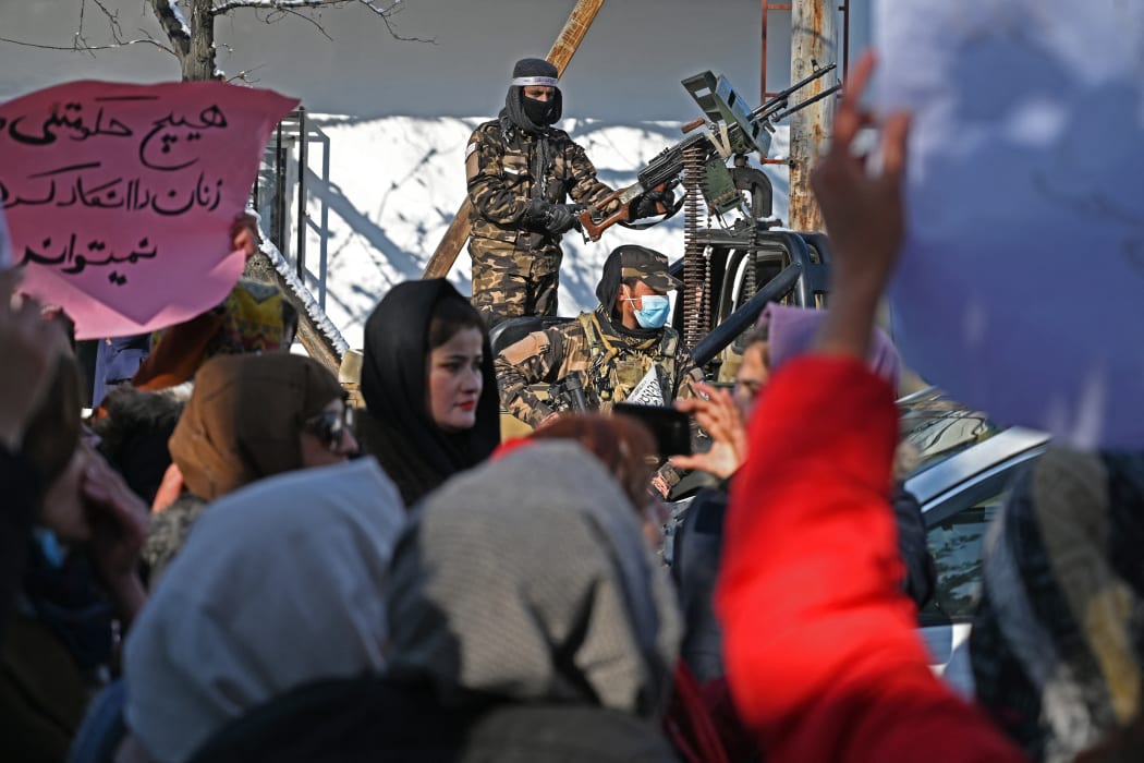 Taliban fighters stand guard on a vehicle as Afghan women protest at Shahr-e Naw in Kabul on December 16, demanding the right to education, jobs and political representation from the Taliban government.