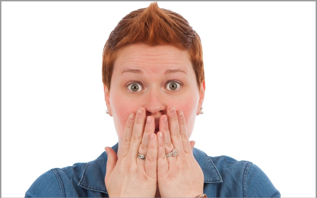An image of a woman with red cheeks looking embarrassed.