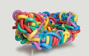 Foam pool noodles in an assortment of colours have been warped into the shape of a single-person couch.